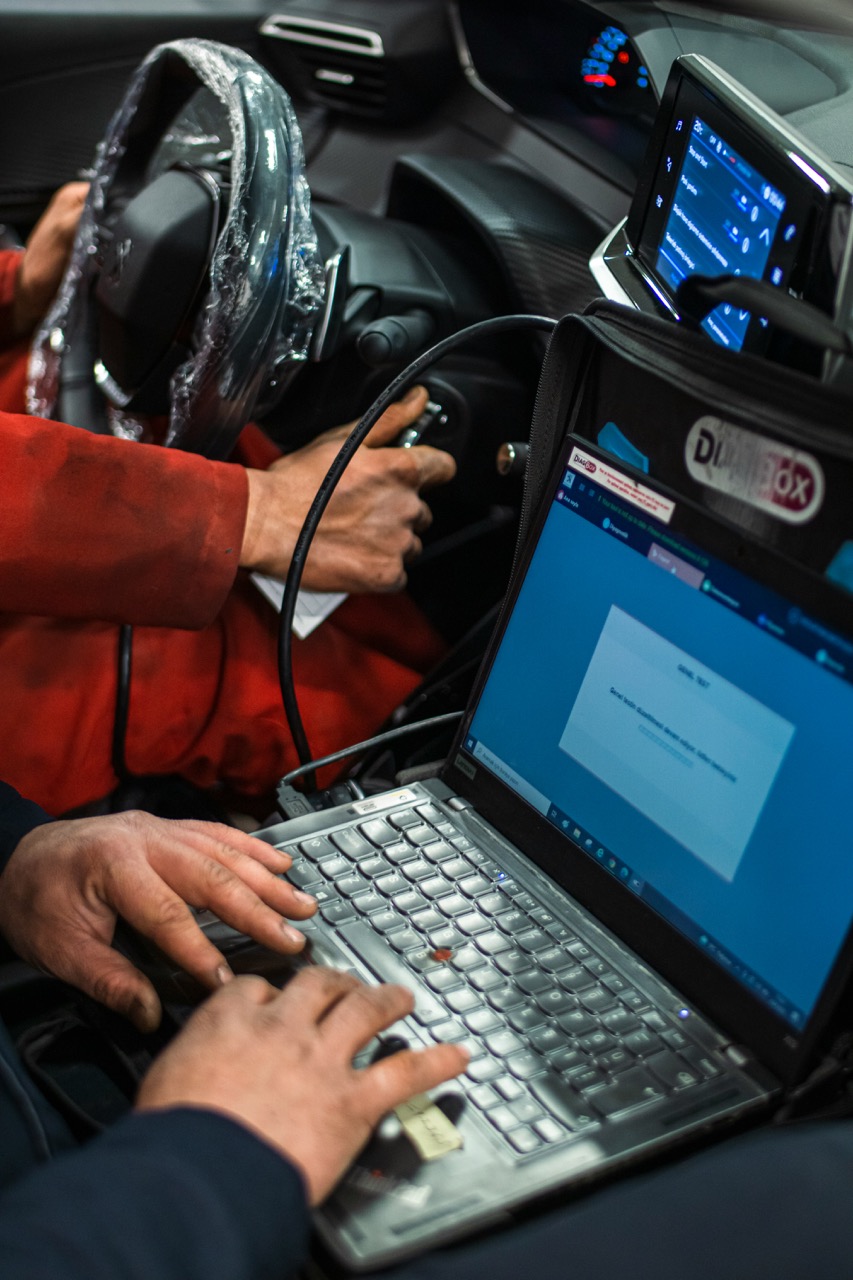 Diagnostika vozu přes notebook v interiéru auta